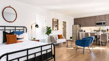 Un dormitorio moderno con cama, mesita de noche y un espejo grande.