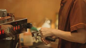 A person operating an espresso machine in a kitchen setting.