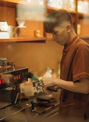 Una persona preparando café con una máquina de espresso en una cocina.