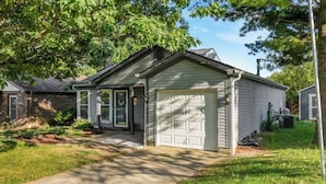A residential house with a garage, a driveway, and a lawn.