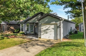 A residential house with a garage, a driveway, and a lawn.
