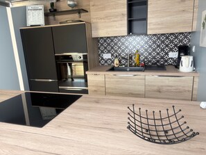 Eine moderne Küche mit Einbauofen, Spüle und Kaffeemaschine.