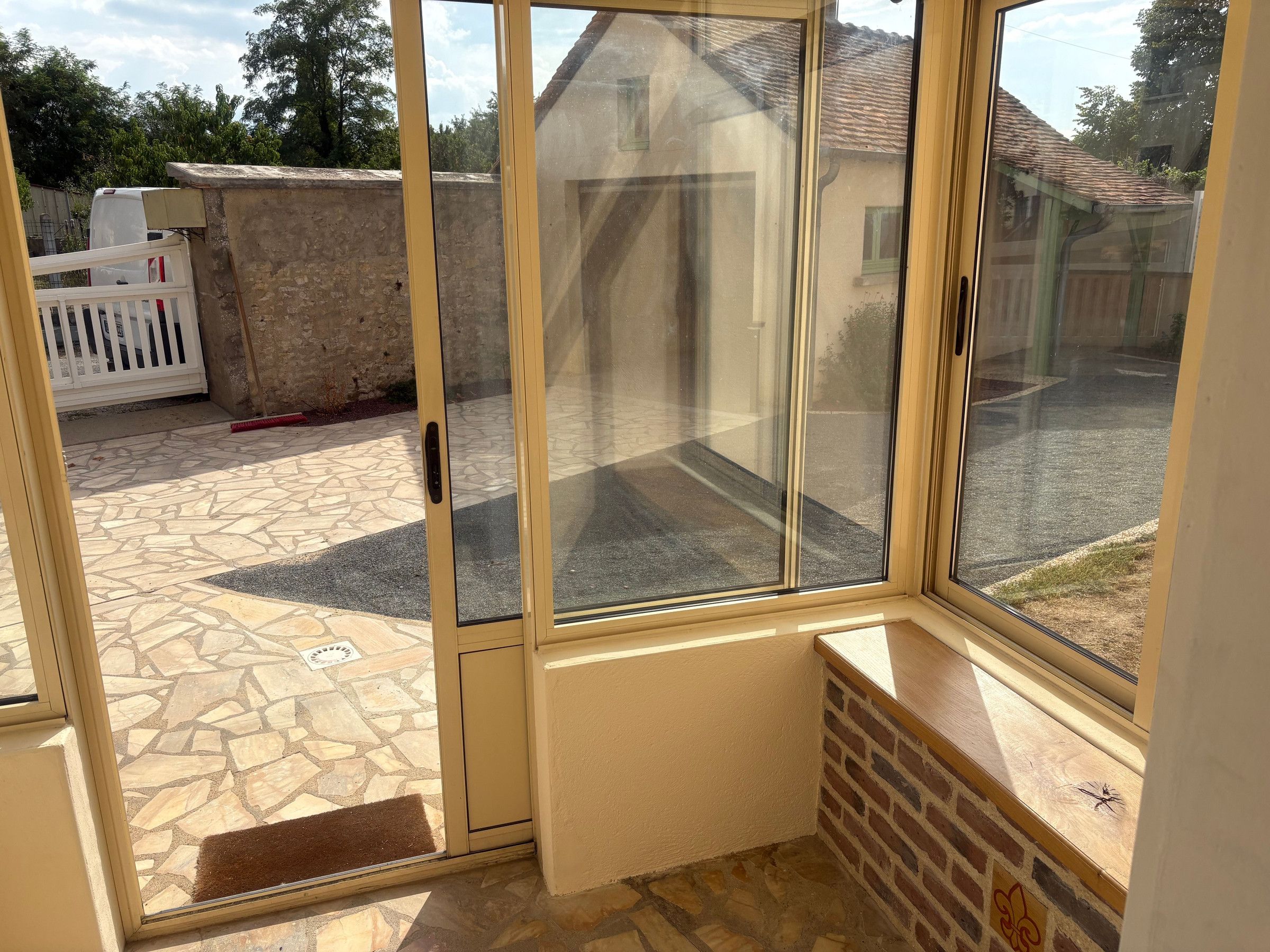 Quarto com porta de vidro deslizante que dá para um alpendre externo com piso de pedra.