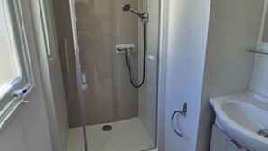 A shower with a glass door, a white sink, and a mirror. - Mobile home AC, pets allowed - 6 guests (Cessenon-sur-Orb)