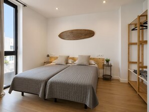 Ein Doppelbett mit Kopfteil, Nachttische, einem Wandregal und Holzboden.