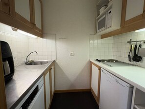 A compact kitchen with a dishwasher, a microwave, and a sink.