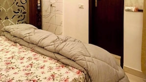 Ein Schlafzimmer mit einem Bett, einer Klimaanlage, einer Tür und einer Wand mit einem Zierpaneel.