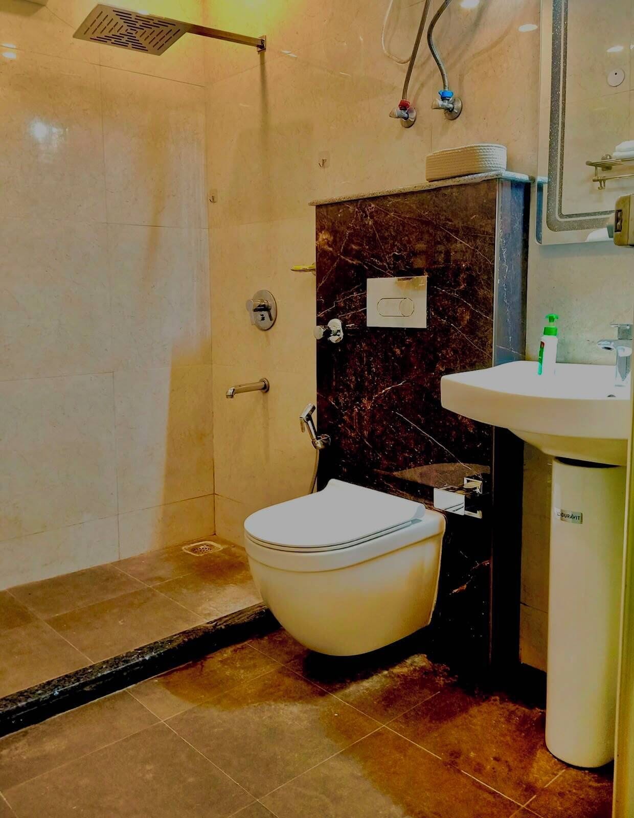 Une salle de bain avec douche, toilettes et lavabo.
