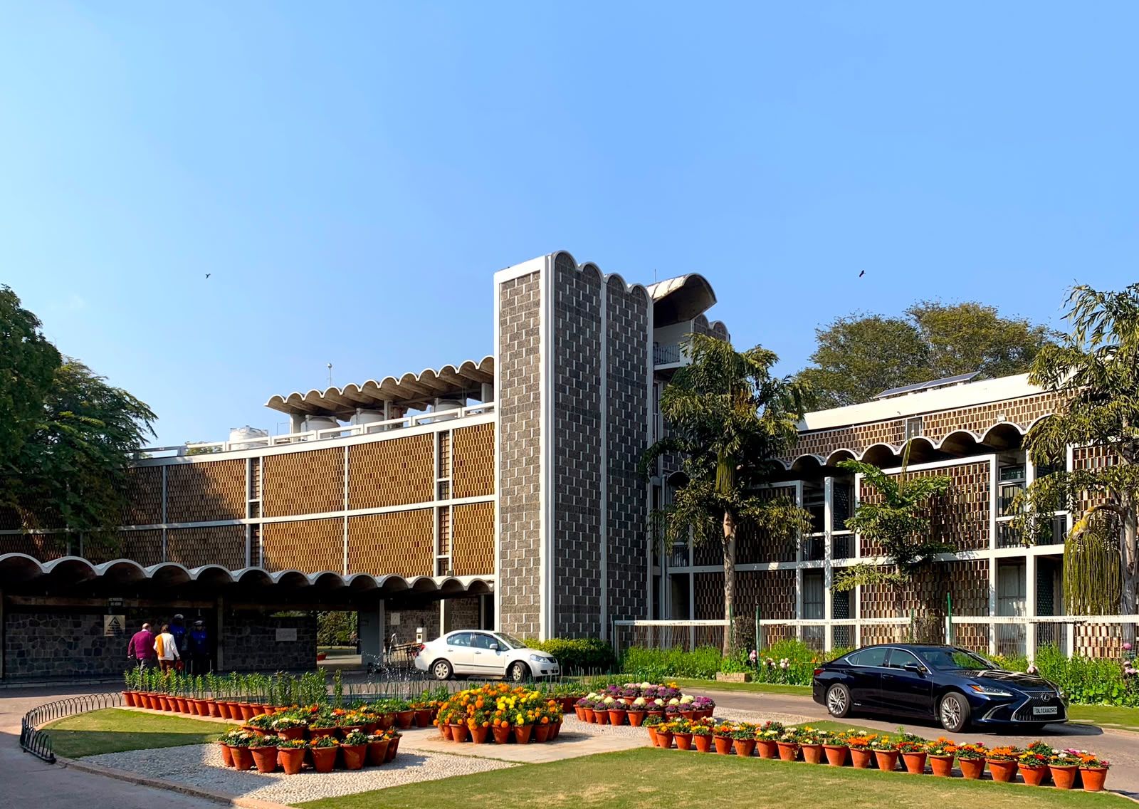 A building with a modern architectural design, featuring a prominent vertical structure and a series of balconies.