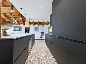 A modern kitchen with dark cabinetry, a patterned floor, and wooden beams on the ceiling. - Comfortable apartment valley view - 10 guests (Saint-Martin-de-Belleville)
