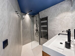 A modern bathroom with a shower, a built-in sink, and a towel rack. - Comfortable apartment valley view - 10 guests (Saint-Martin-de-Belleville)