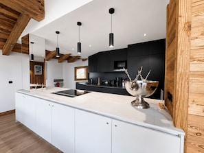 A modern kitchen with a large island, pendant lighting, and wooden beams on the ceiling. - Comfortable apartment valley view - 10 guests (Saint-Martin-de-Belleville)