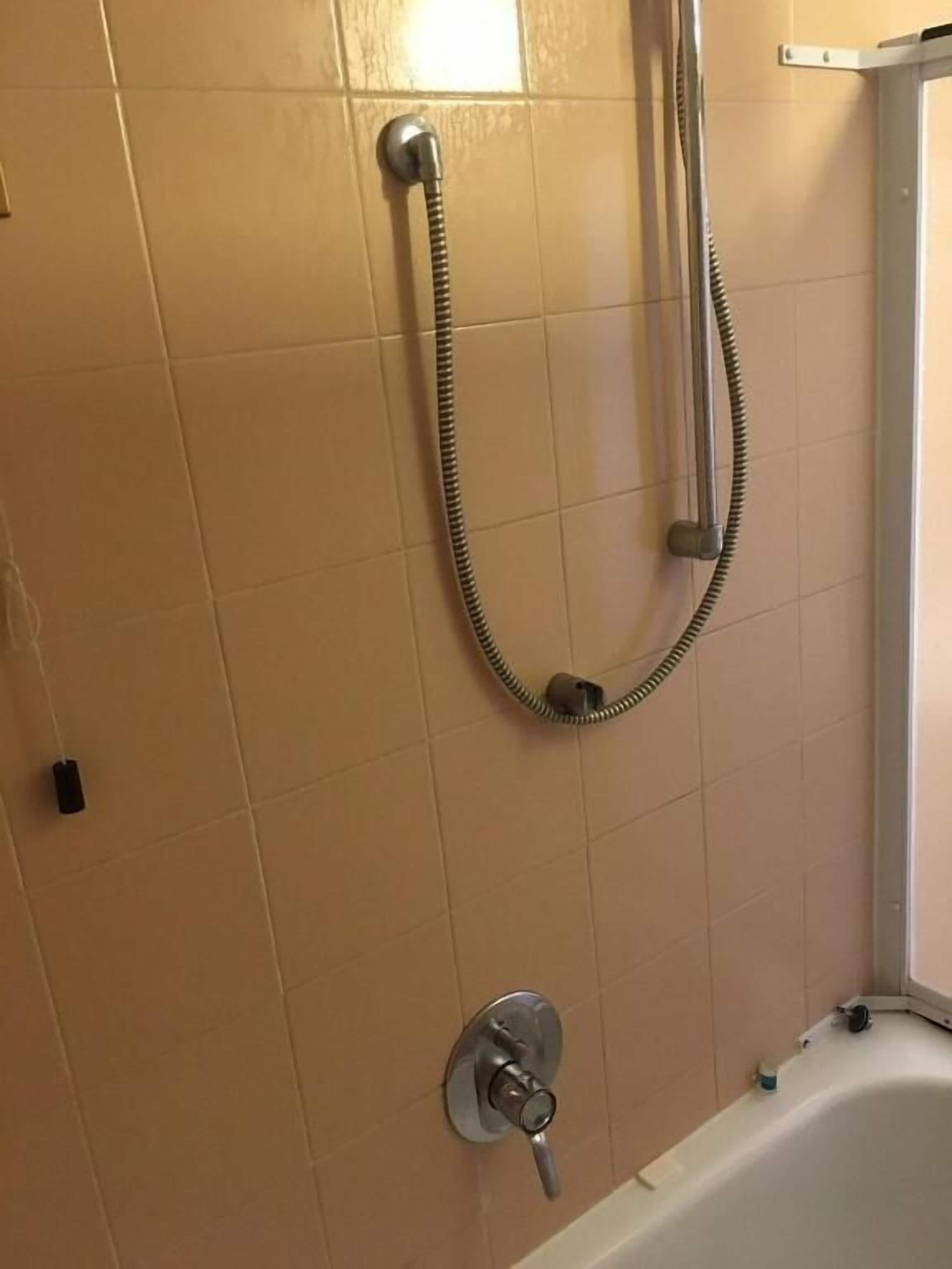 Un baño con ducha, bañera y retrete.