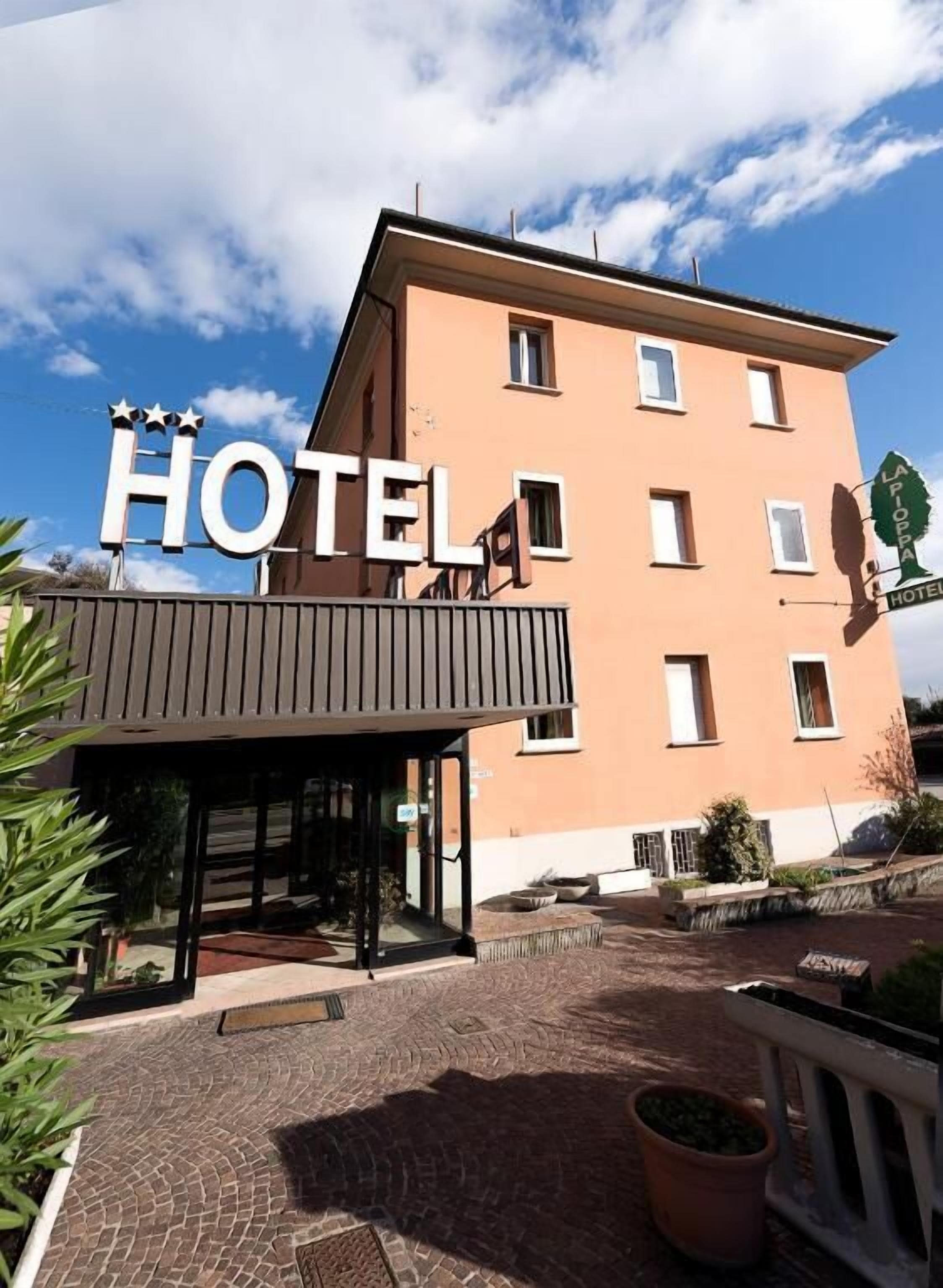 Un edificio de hotel con un letrero que dice 'HOTEL' y un letrero más pequeño que indica 'LA POSTE HOTEL'.