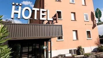 Un edificio de hotel con un letrero que dice 'HOTEL' y un letrero más pequeño que indica 'LA POSTE HOTEL'.
