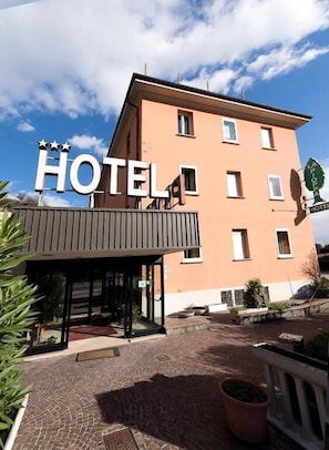 Un edificio de hotel con un letrero que dice 'HOTEL' y un letrero más pequeño que indica 'LA POSTE HOTEL'.