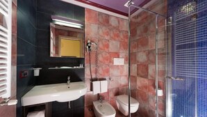Une salle de bain équipée d’un lavabo, d’un bidet, de toilettes et d’une douche à parois en verre.