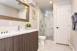 A modern bathroom with a marble shower, a white toilet, and a wooden vanity. - The Penn Hotel - Queen Bed, AC & Walk to Gaslamp!! (San Diego)