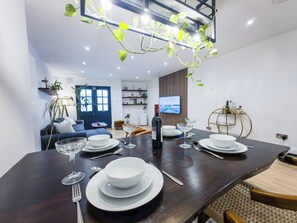 A modern dining area with a dark wooden table set for four, surrounded by chairs. - Luxury 2 bed maisonette in Spitalfields zone 1 - Pass the Keys (London)