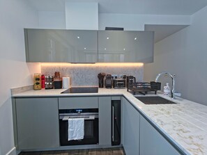 A modern kitchen with a built-in oven, a coffee machine, and a sink. - Sleek flat near the City 5 min from station - Pass the Keys (London)