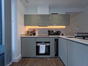 A modern kitchen with a built-in oven, a coffee maker, and a sink. - Sleek flat near the City 5 min from station - Pass the Keys (London)