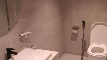 Een moderne badkamer met een groot wastafel, toilet en douche.