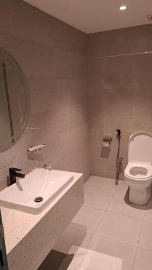 A modern bathroom with a large sink, toilet, and shower. - Al Rayyan Tower (Jeddah)