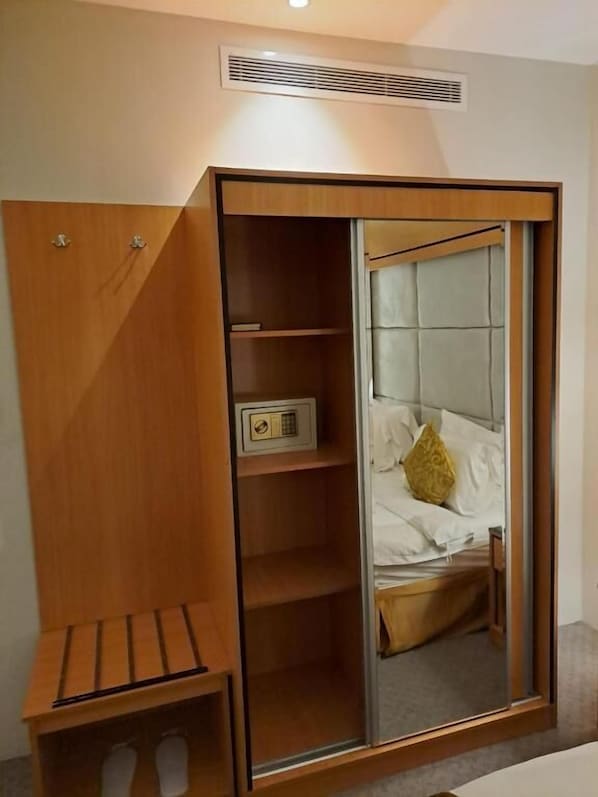 A room with a wardrobe, a bed with a headboard, and a small table. - Al Rayyan Tower (Jeddah)