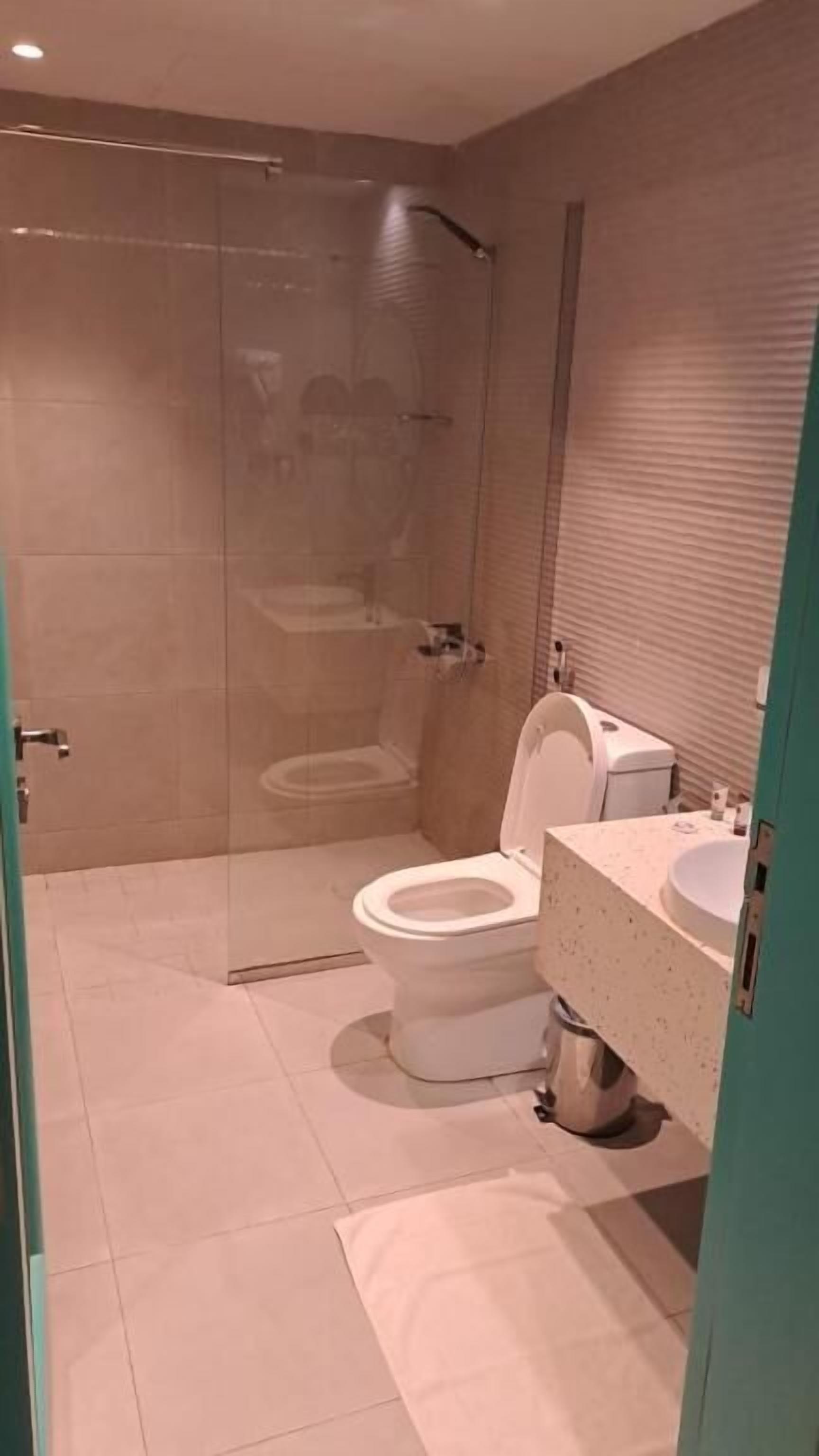 Un baño moderno con ducha de vidrio, inodoro y lavamanos.