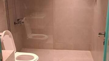 Une salle de bain moderne avec une douche à parois de verre, des toilettes et un lavabo.