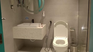 A bathroom with a white toilet, a sink, and a mirror. - Al Rayyan Tower (Jeddah)
