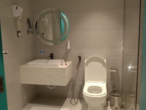 A bathroom with a white toilet, a sink, and a mirror. - Al Rayyan Tower (Jeddah)