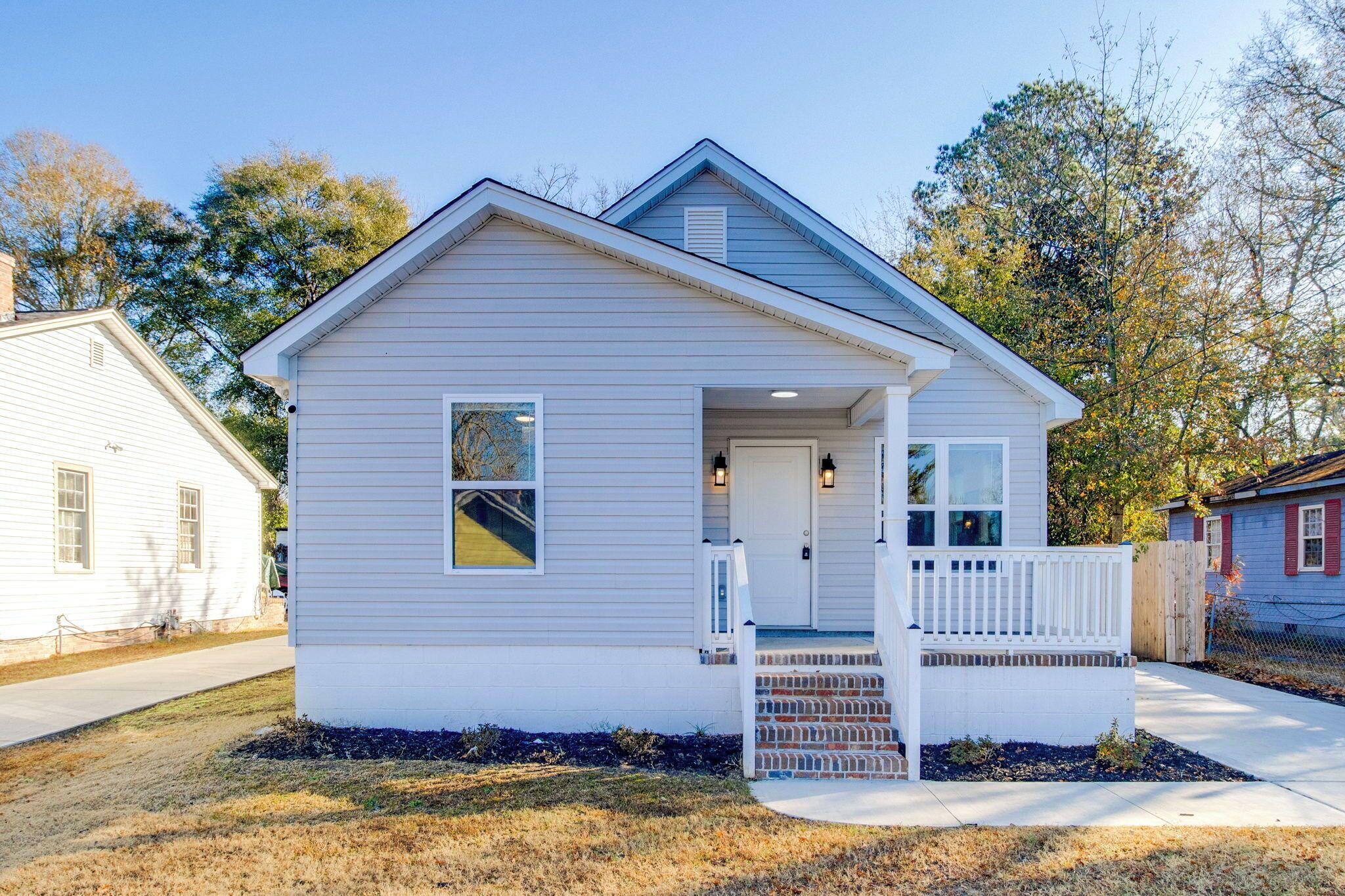 A single-story house with a front porch, a small window, and a door.