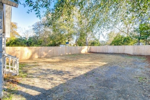 A fenced backyard with a gravel path leading to a wooden deck. - 3-bedroom house in beautiful Sumter with cool AC breeze (Sumter)