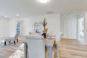 A dining area with a table set for four, surrounded by patterned chairs. - 3-bedroom house in beautiful Sumter with cool AC breeze (Sumter)