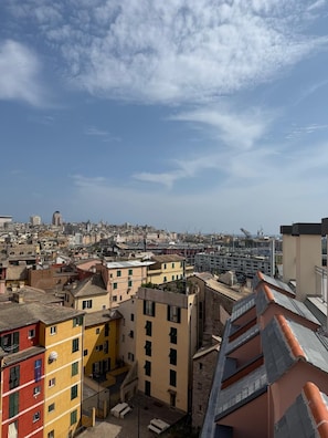 A cityscape with a mix of residential and commercial buildings, including a prominent yellow building with a flat roof and a red building with a sloped roof. - Hotel Europa (Genoa)