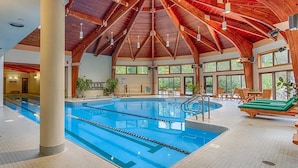 An indoor swimming pool with a wooden ceiling and large windows. - The Woods Killington - 2B with Spa, Pool & Jacuzzi (Killington)