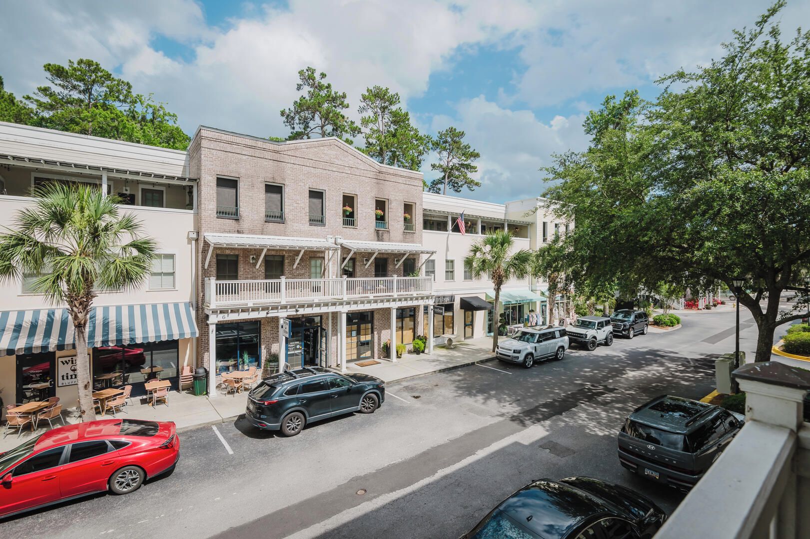 A street view of a multi-story building with a ground-level restaurant and upper-level shops.