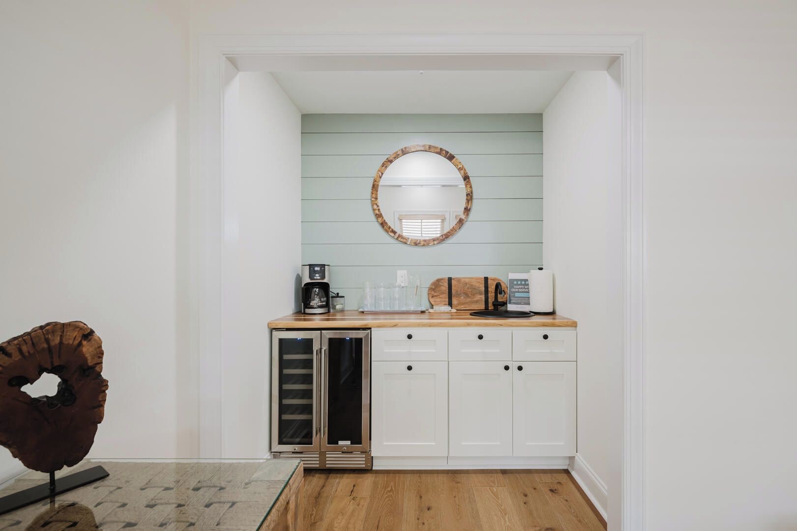 A compact kitchen with a built-in refrigerator, a coffee maker, and a microwave on the countertop.