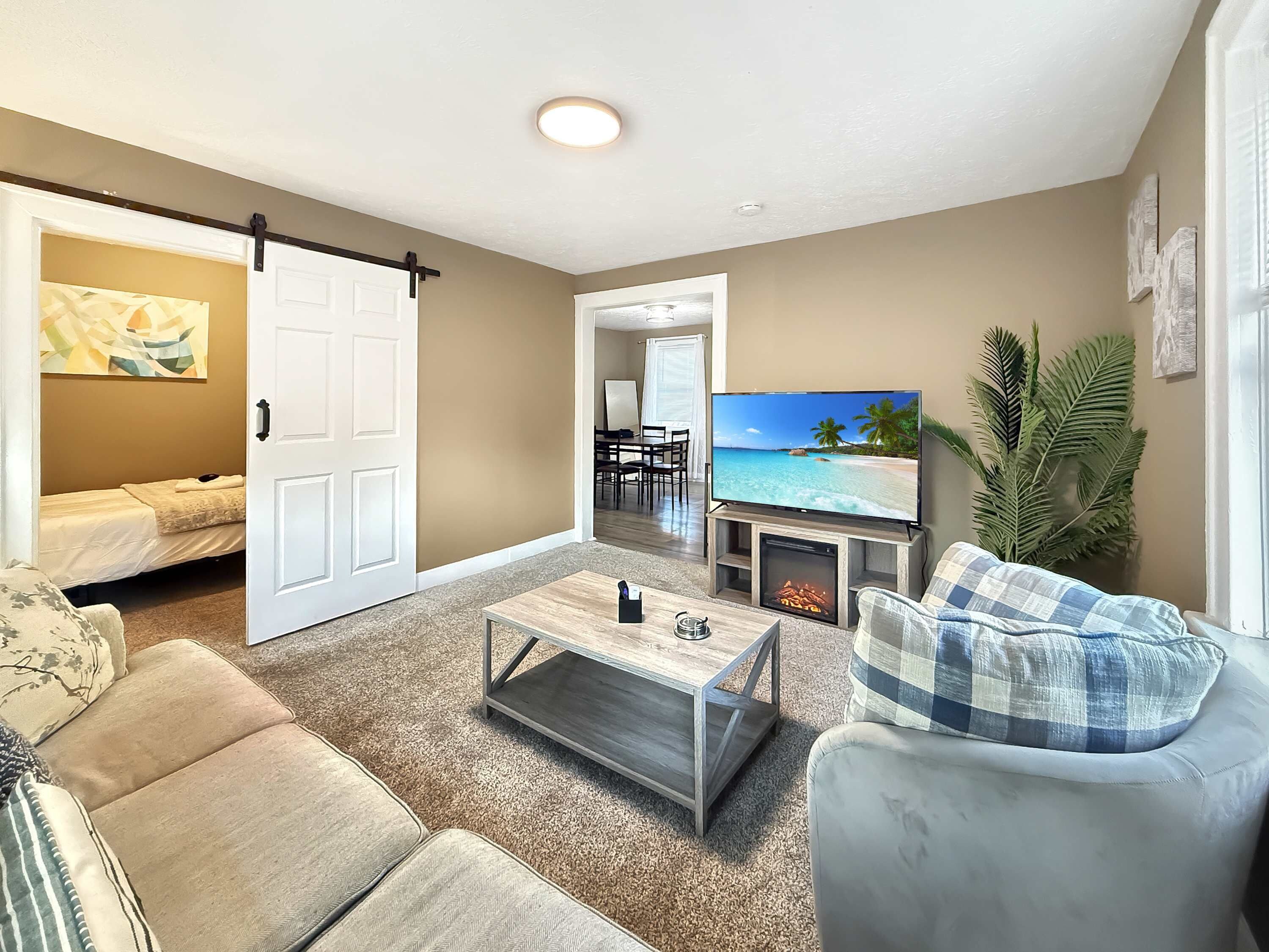 A living room with a television, a fireplace, a sofa, and a coffee table.