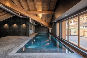 An indoor swimming pool with a view of the outside. - Solévivre – Terrace | Spa | View| Alpe d’Huez (Huez)