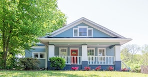 A two-story house with a front porch, a red door, and a year marked as 1920.