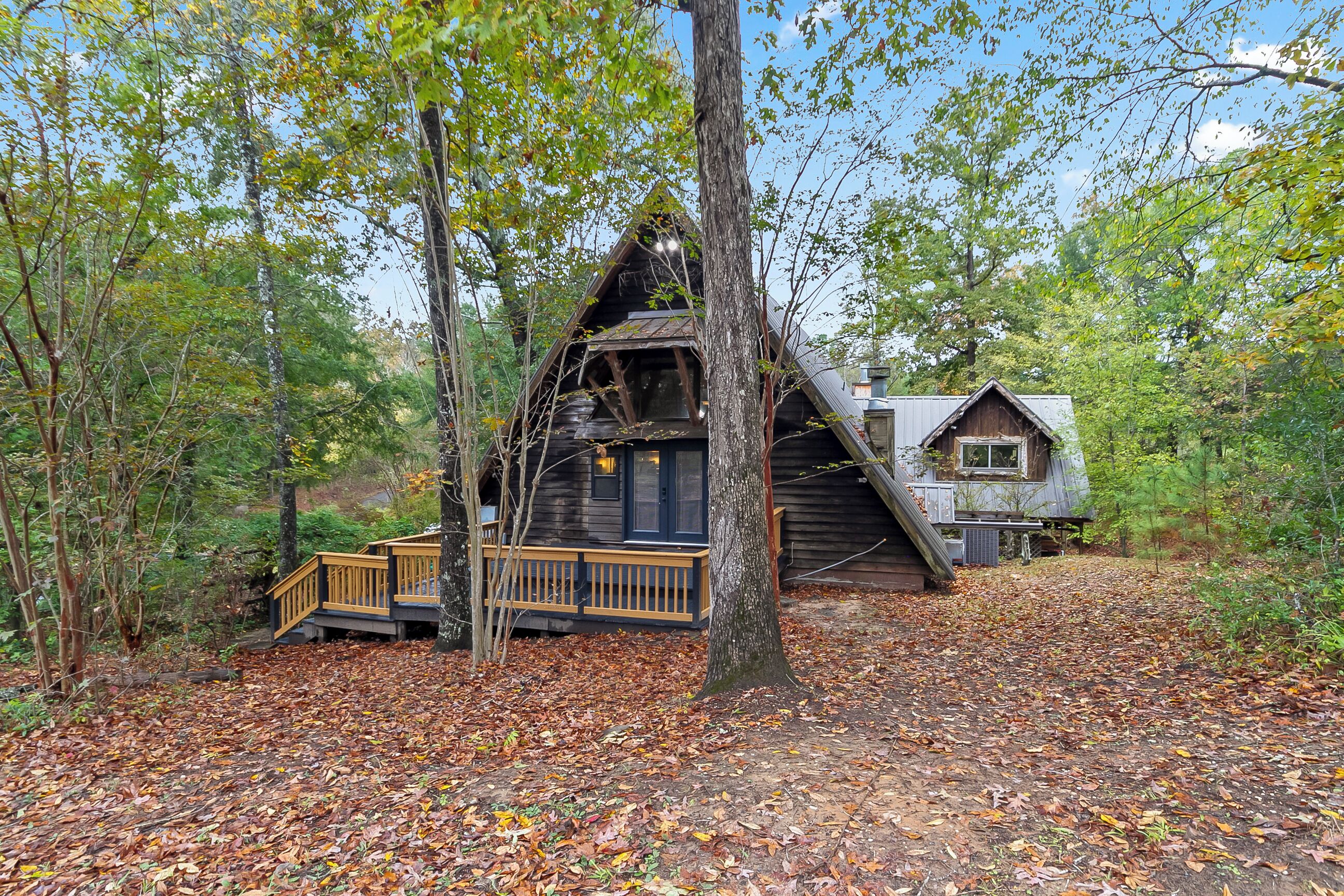 A cabin with a wooden deck and a small staircase leading to the entrance.