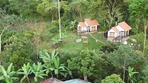 A rural property with a large house, a smaller structure, and a fenced area with a metal roof.
