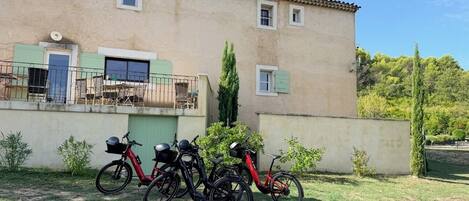 A building with a flat roof, a balcony, and a bicycle parked in front.