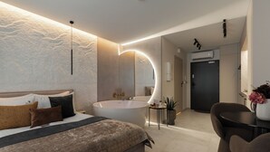 Une chambre moderne avec un grand lit, une baignoire et un bureau avec une chaise.