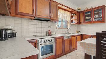 A kitchen with wooden cabinets, a stove, a sink, and a dishwasher.