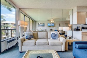 Ein Wohnzimmer mit einer Couch, einem Couchtisch und Blick ins Freie.