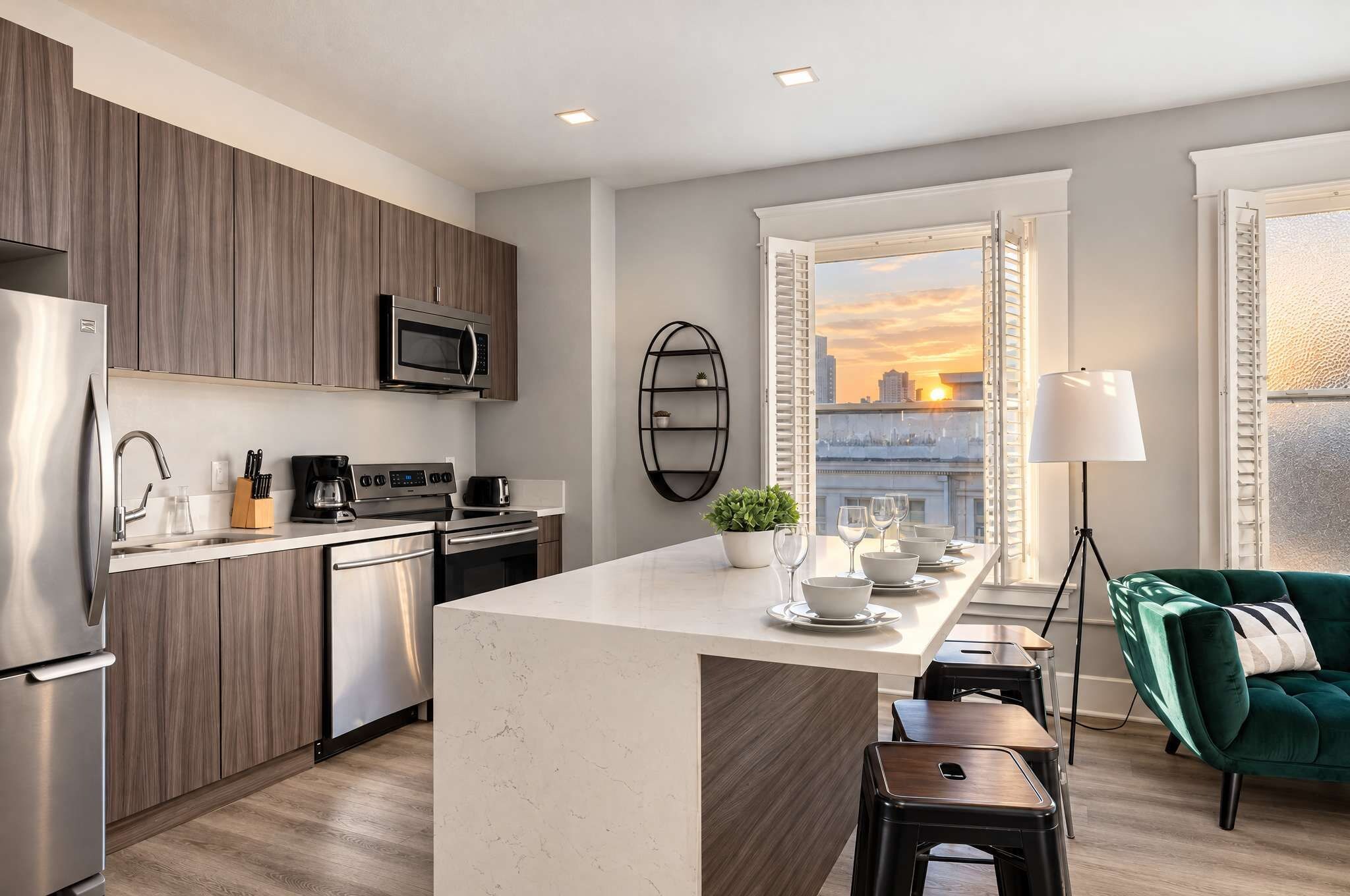 A modern kitchen with a central island, stainless steel appliances, and a city view through the window.