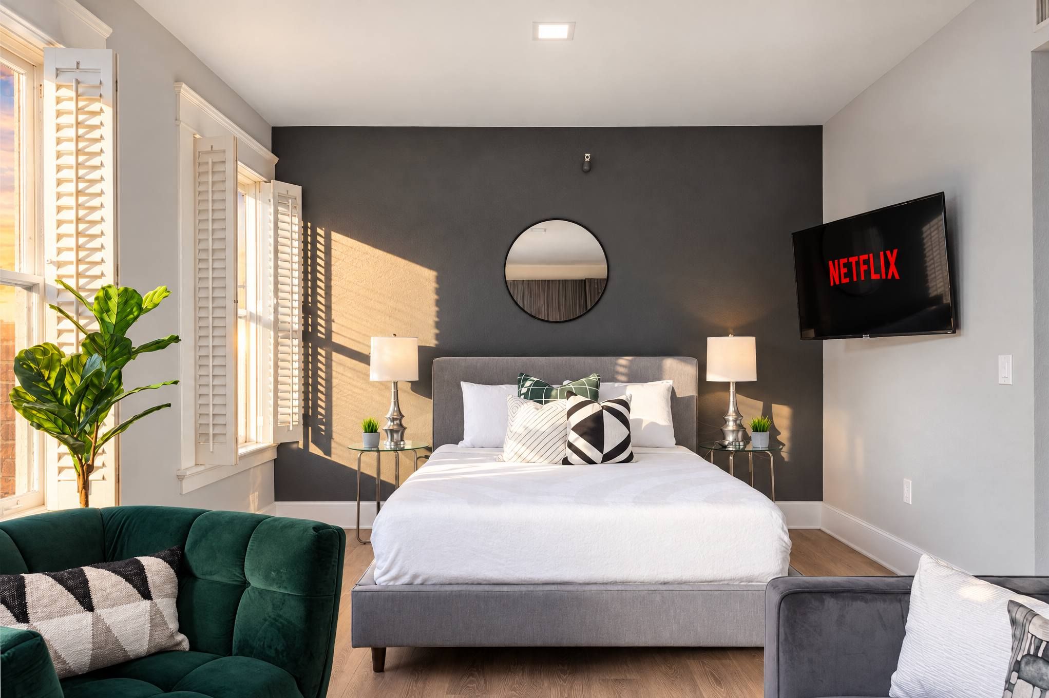 🛋 Cozy bedroom seating corner—complemented by wall-mounted smart TV and plush green armchair.